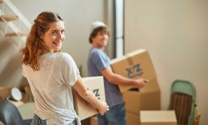 boy wearing a blue t-shirt and girl wearing white t-shirt holding XYZ Storage moving boxes