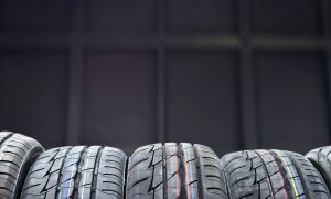 black background, five tires in the front with thin blue, yellow, white, and red stripes